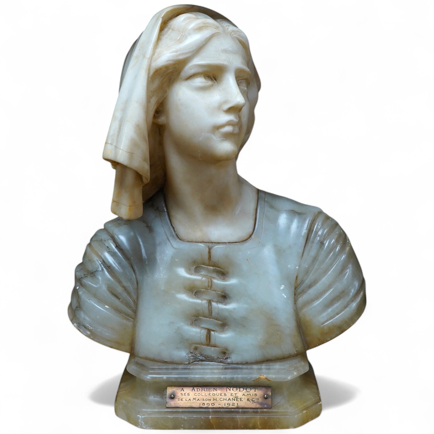 After Giuseppe Bessi (1857-1922) carved alabaster bust of Joan of Arc, plaque reads ‘A Adrien Nodot ses collègues et amis de La Maison H. Chanée & Cie 1890-1921’, 30cm. Condition - fair to good